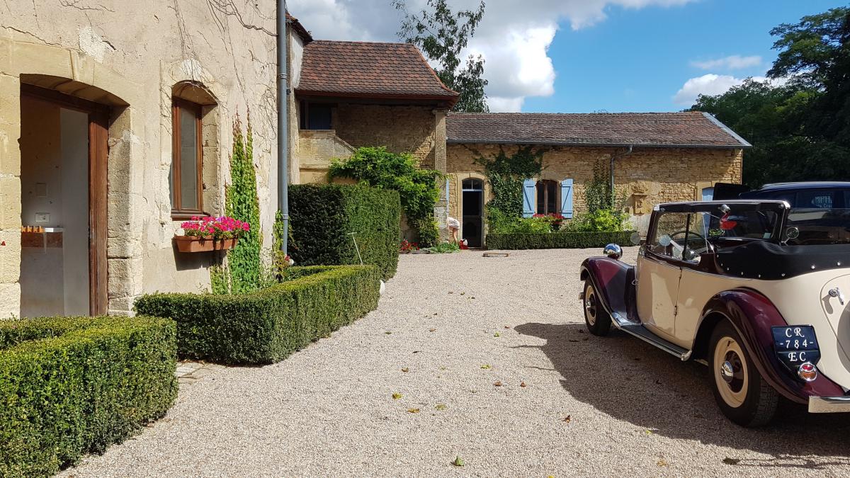 depart des maries voiture de collection salle poterne gite de la tour du pont levis - mariage - cour chateau médiéval - Crédit photo : Aurore THIEBAUT